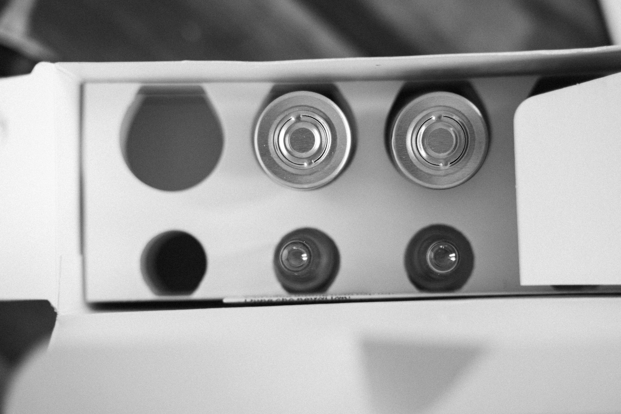 Top view of open battery packaging in black and white, showcasing round cells.